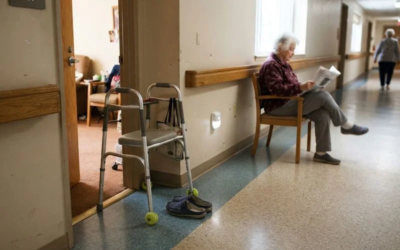 A well-lit assisted living hallway with grab bars and non-slip flooring, showing fall prevention features